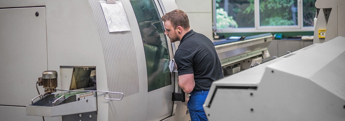 Einrichter bedient CNC-Drehmaschine zur Herstellung von CNC-Drehteilen.