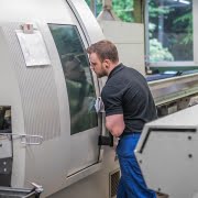 Einrichter bedient CNC-Drehmaschine zur Herstellung von CNC-Drehteilen.